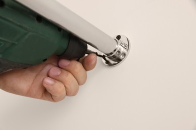 Photo of Worker installing new metal pipes with electric drill, closeup