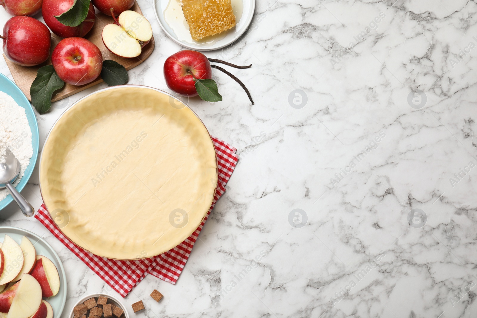 Photo of Flat lay composition with raw dough and ingredients on white marble table, space for text. Baking apple pie