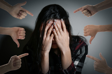 People bullying young woman near beige wall