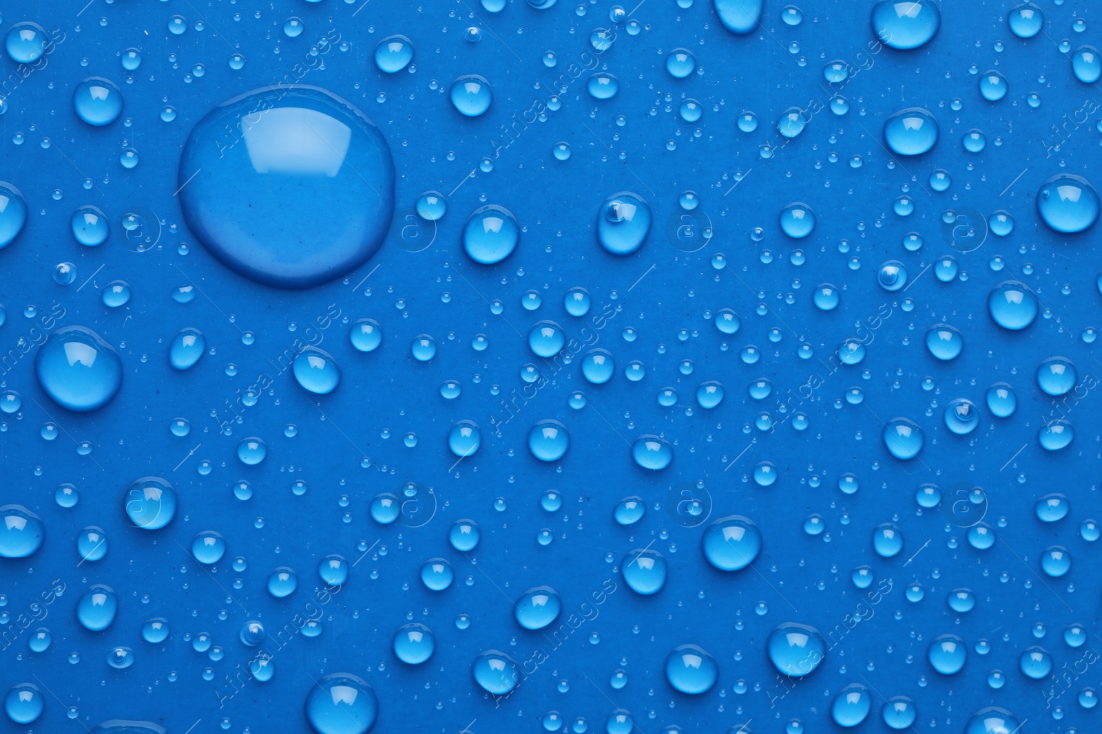 Photo of Water drops on blue background, top view