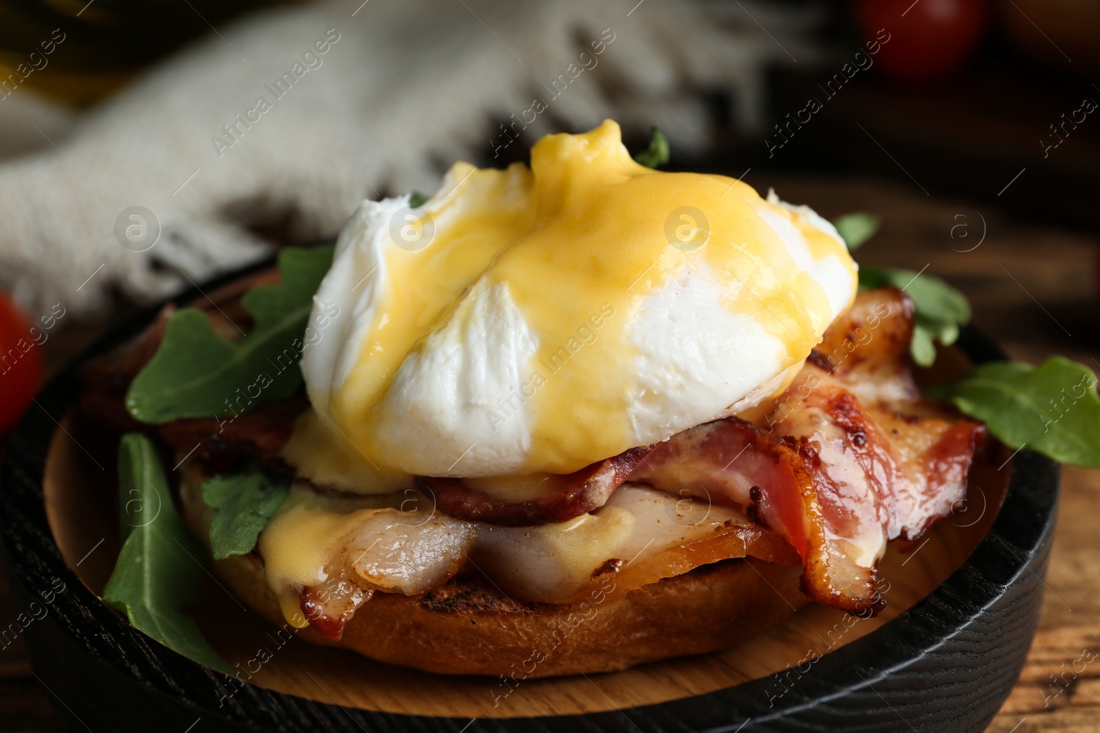 Photo of Delicious egg Benedict served on wooden table, closeup