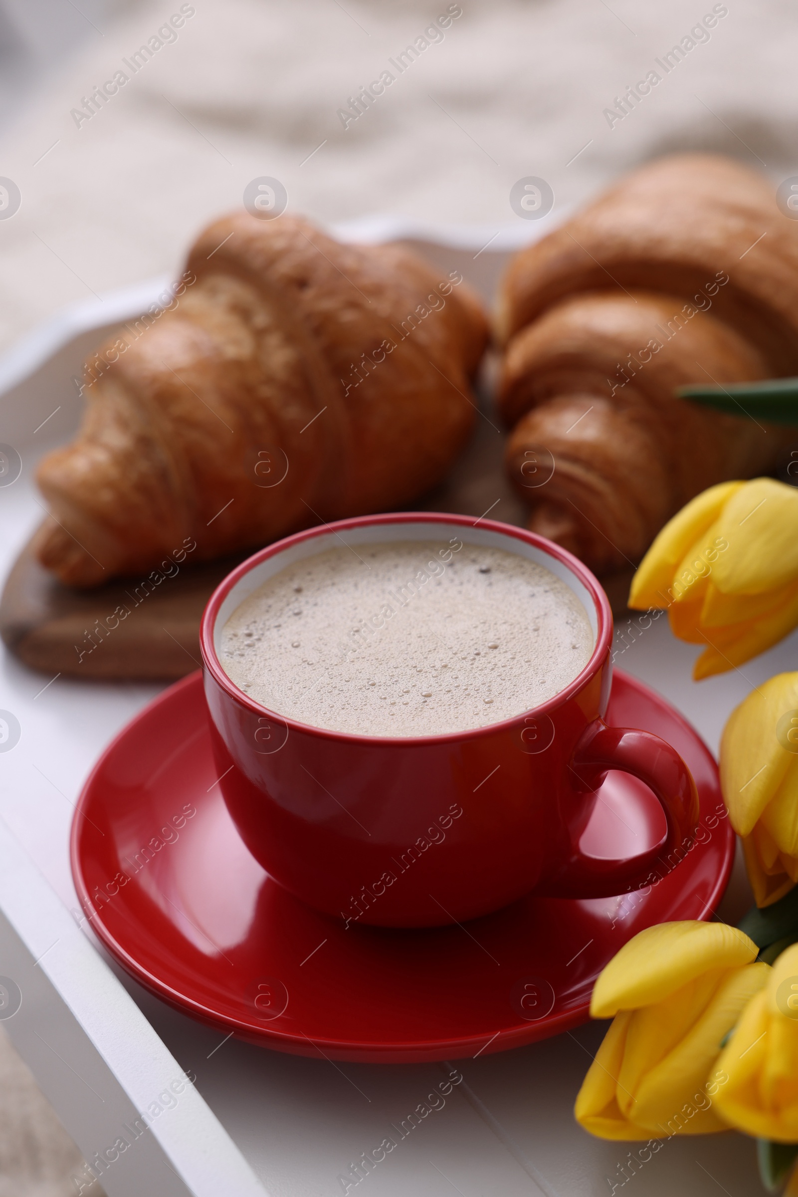 Photo of Morning coffee, flowers and croissants on white wooden tray