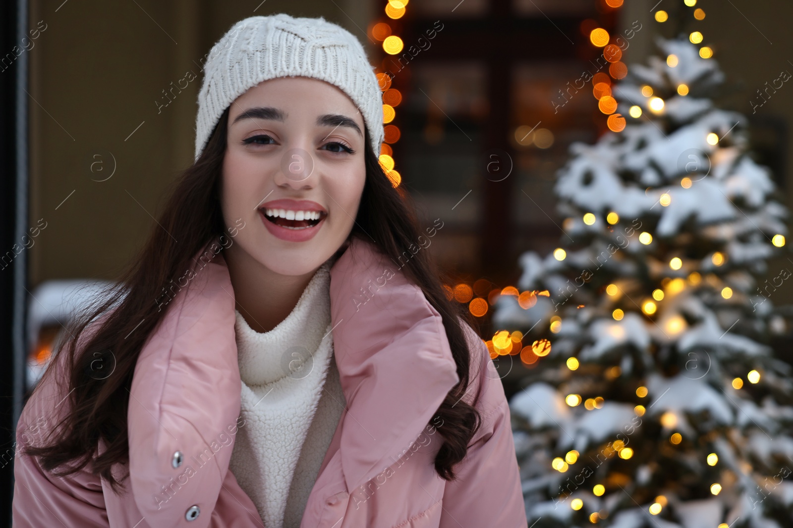 Photo of Portrait of happy woman on city street in winter. Space for text