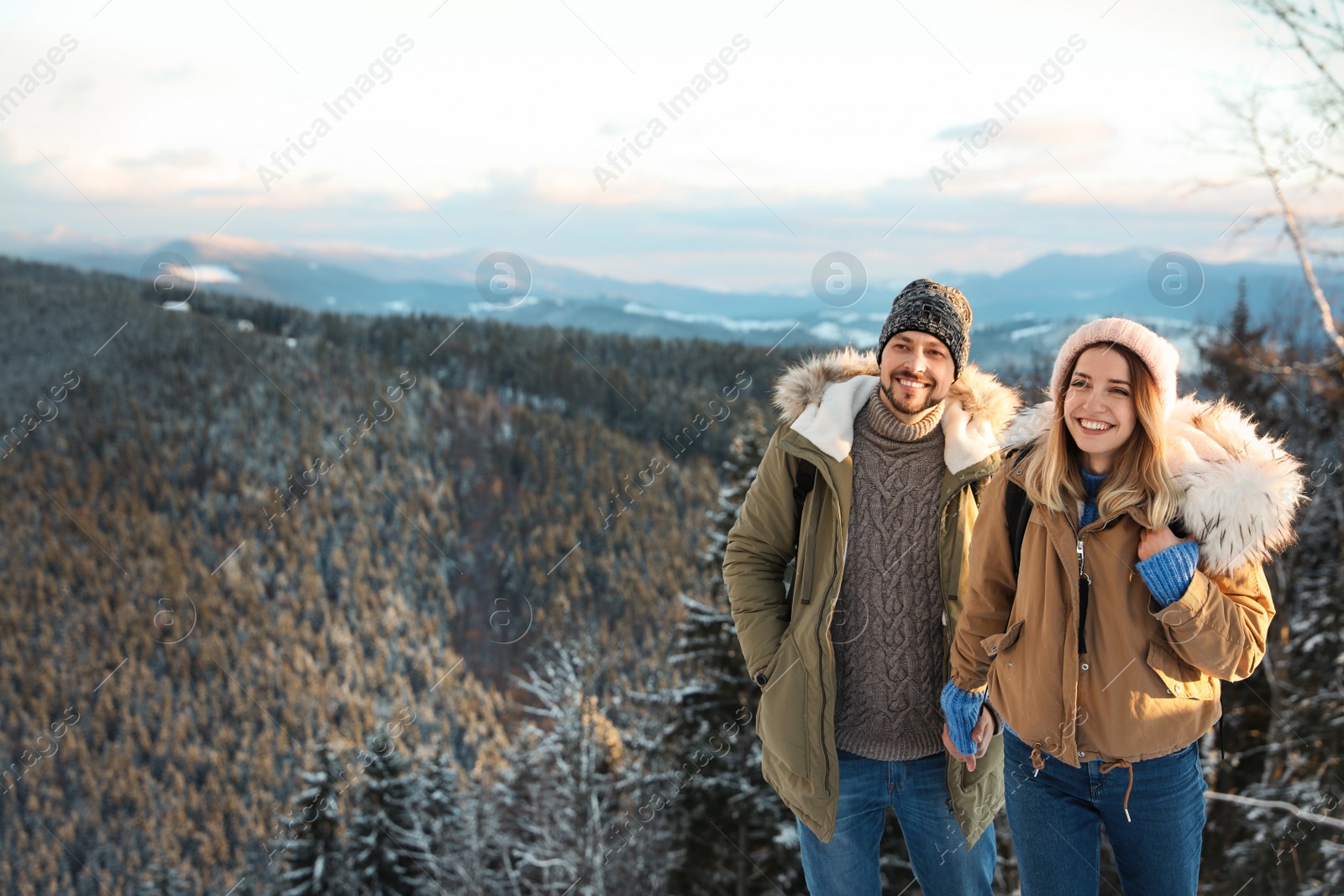 Photo of Happy couple spending winter vacation together in mountains. Space for text