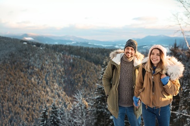 Photo of Happy couple spending winter vacation together in mountains. Space for text