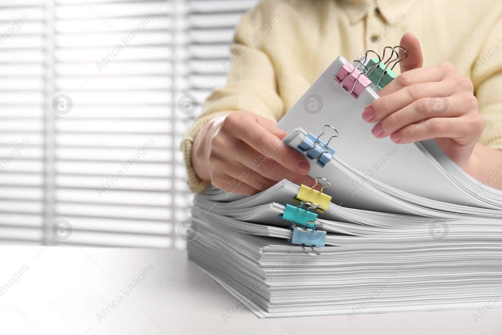 Photo of Woman working with documents at table in office, closeup. Space for text