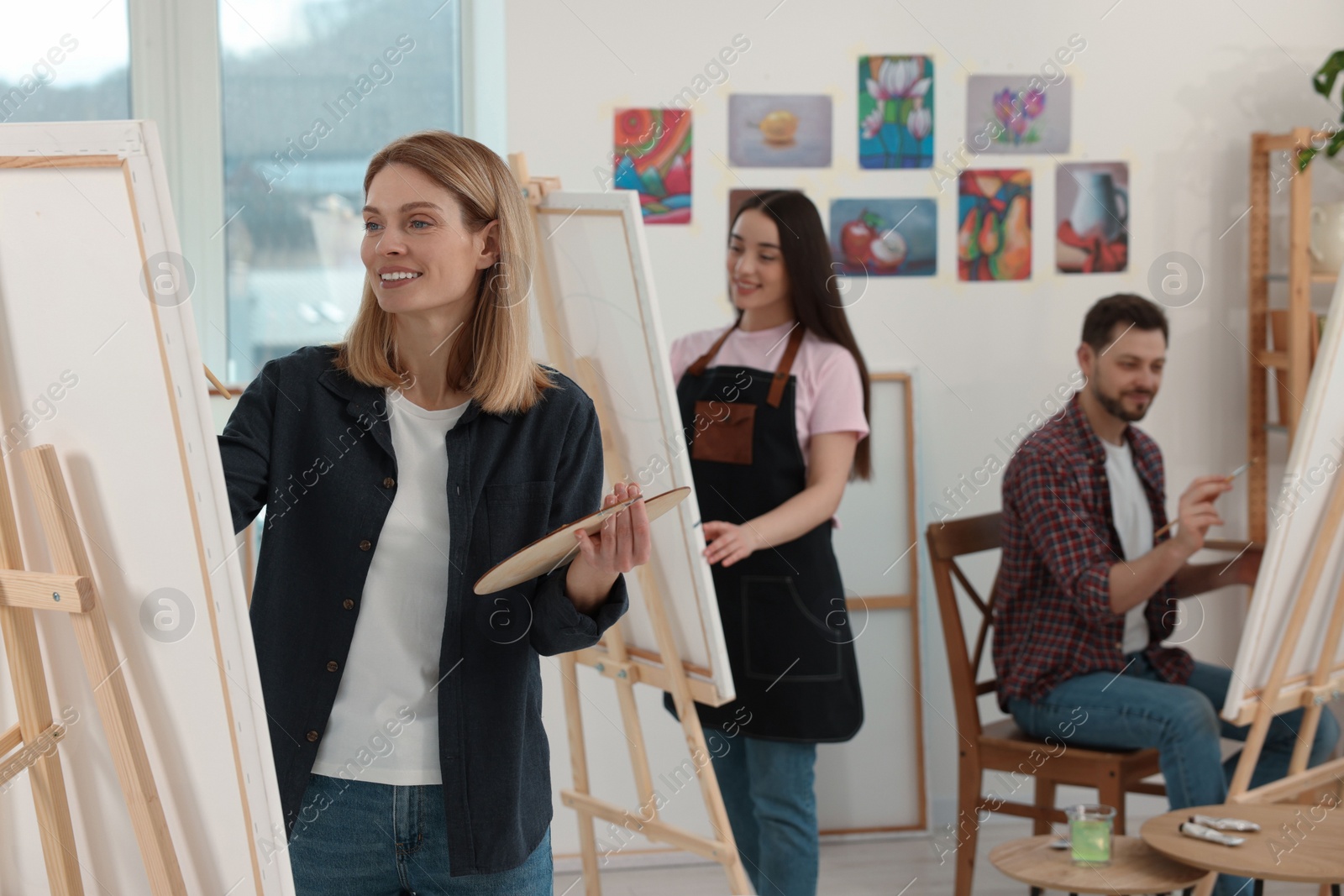 Photo of Group of students attending painting class in studio. Creative hobby