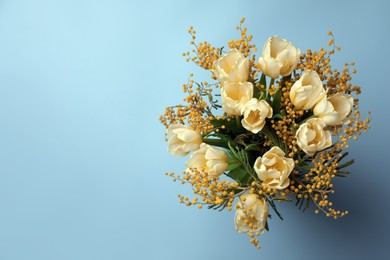 Bouquet with beautiful tulips and mimosa flowers on light grey background, top view. Space for text