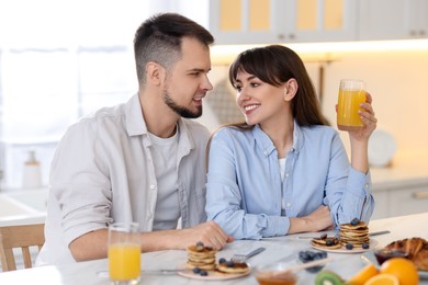 Happy couple having tasty breakfast at home