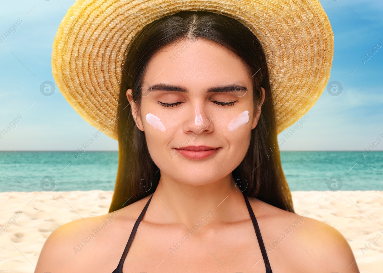 Image of Sun protection. Beautiful young woman with sunblock on her face near sea, closeup