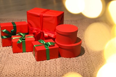 Photo of Beautifully wrapped Christmas gifts on rug indoors