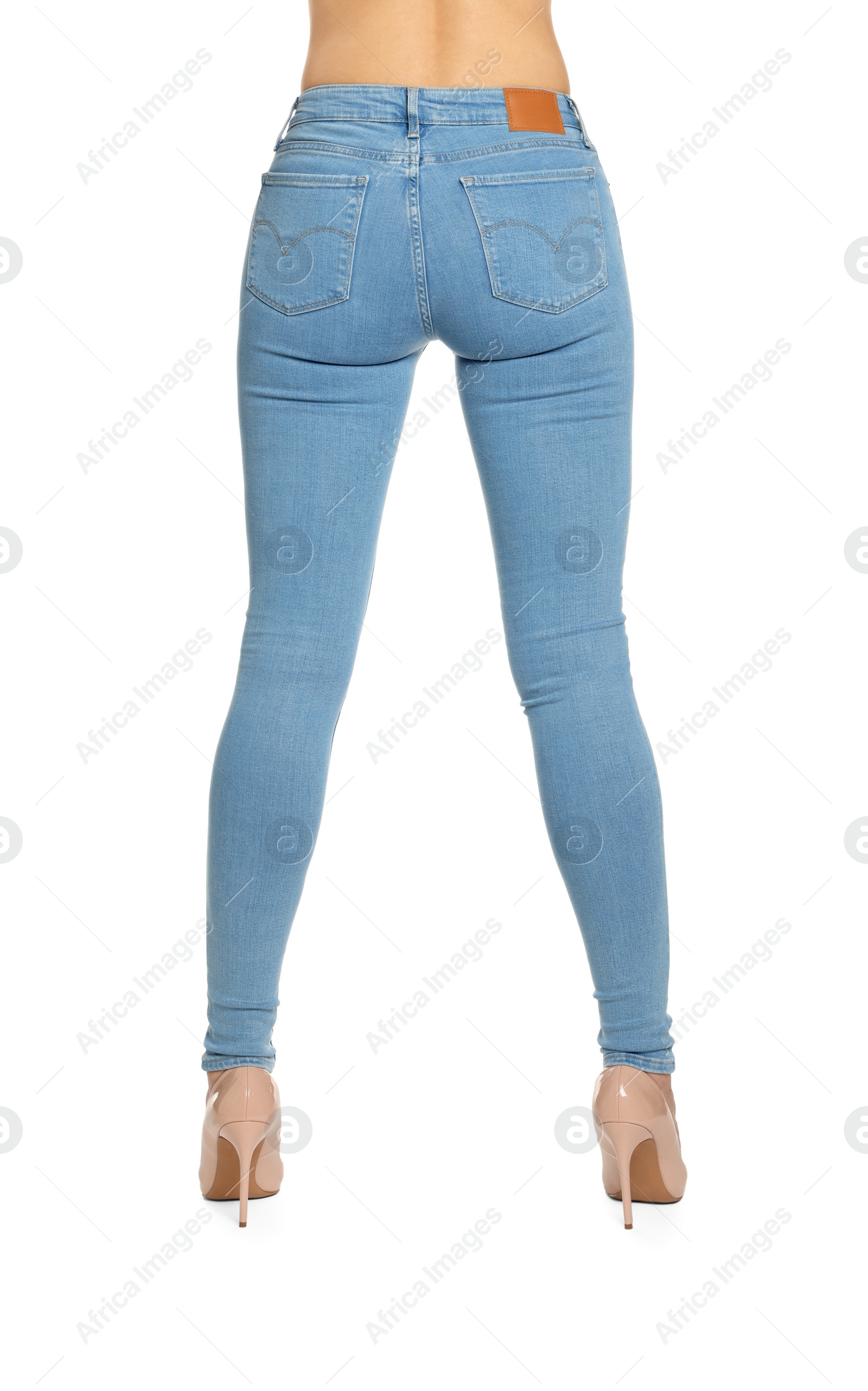 Photo of Woman wearing stylish light blue jeans and high heels shoes on white background, closeup