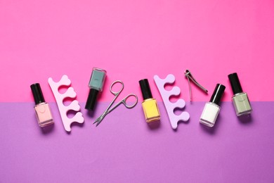 Photo of Nail polishes, clippers, scissors and toe separators on color background, flat lay