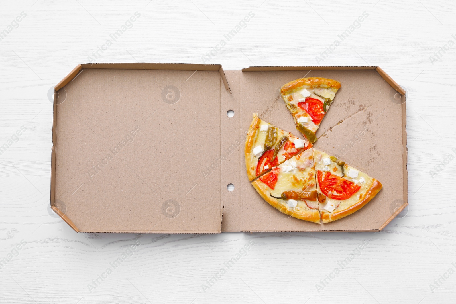 Photo of Cardboard box with tasty pizza slices on wooden background, top view