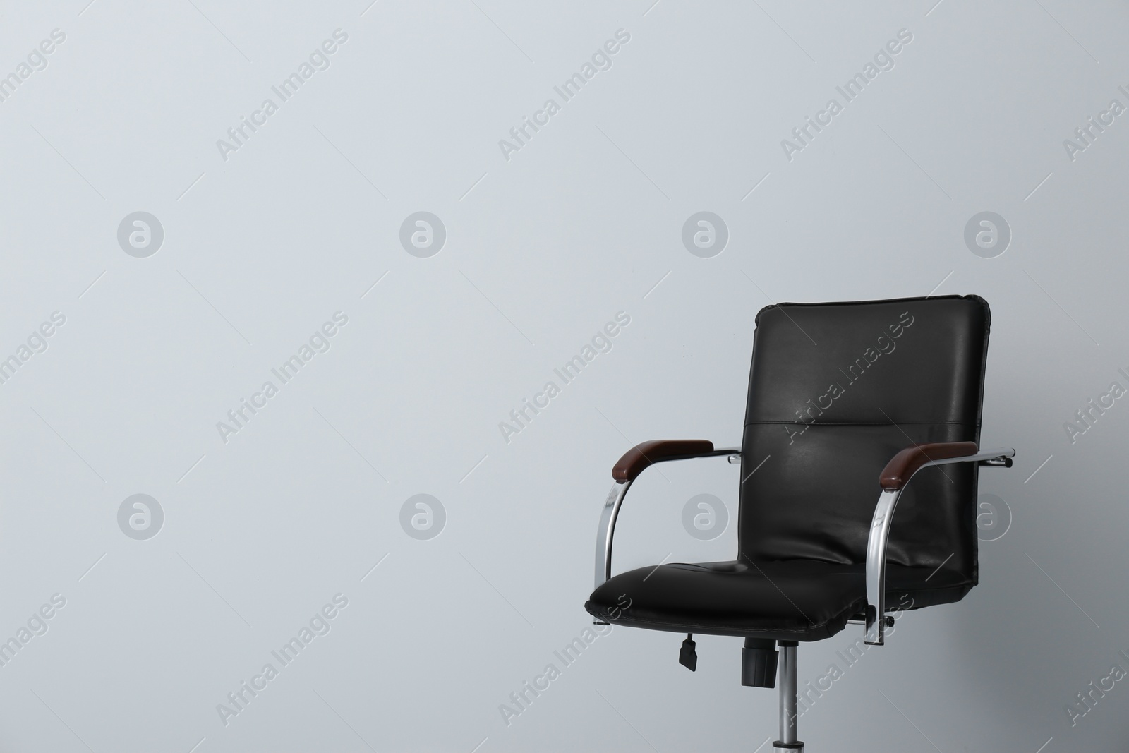 Photo of Comfortable office chair on light background. Space for text