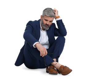 Mature businessman in stylish clothes sitting on white background