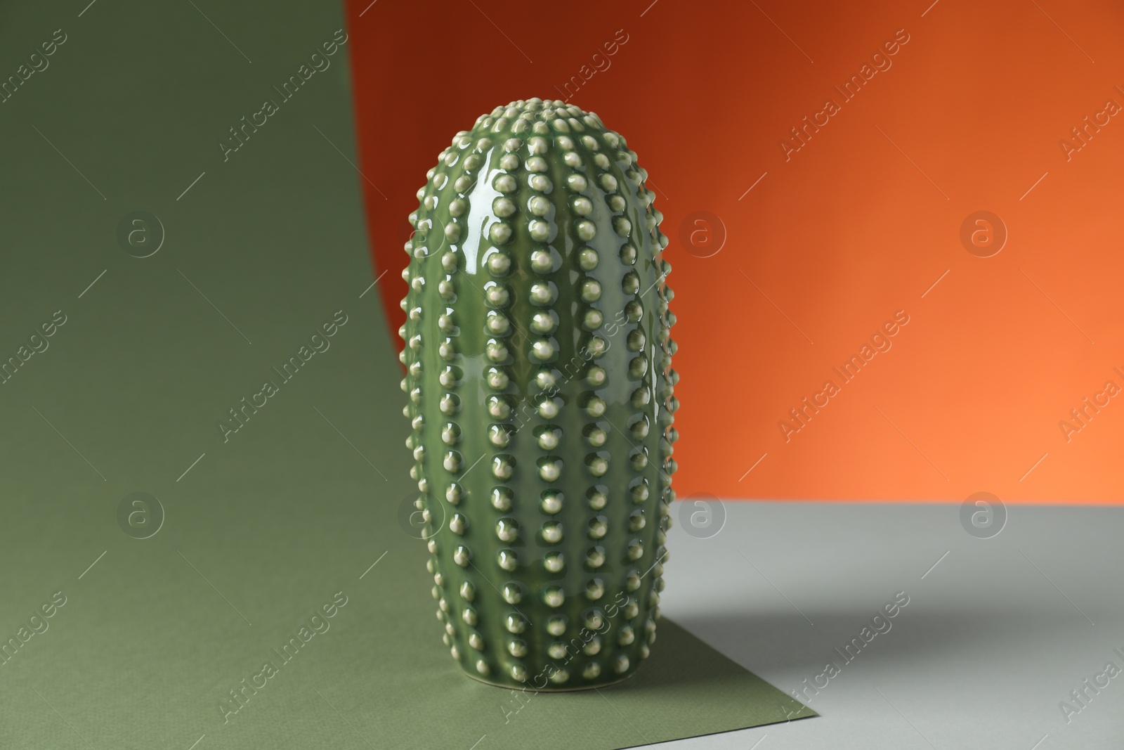 Photo of One beautiful ceramic cactus on color background
