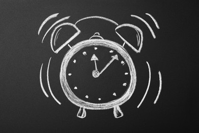 Photo of Drawn alarm clock on blackboard. School time