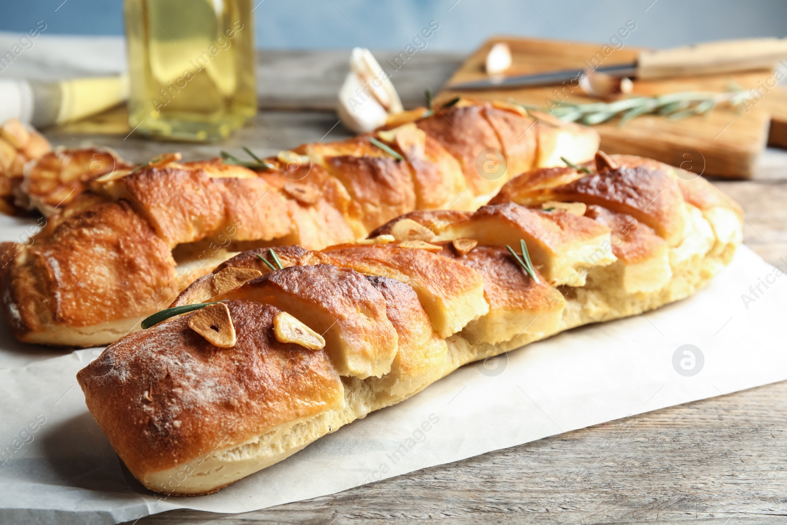 Photo of Delicious homemade garlic bread with rosemary on table