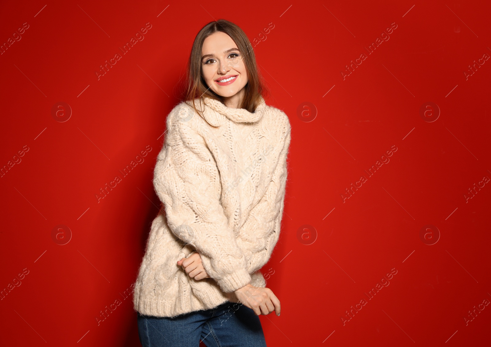 Photo of Young woman wearing Christmas sweater on red background