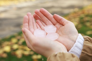 Photo of Woman holding hail grains after thunderstorm outdoors, closeup