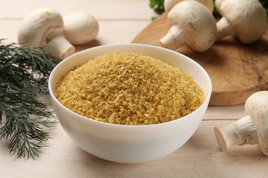 Photo of Raw bulgur in bowl, mushrooms and dill on light wooden table, closeup