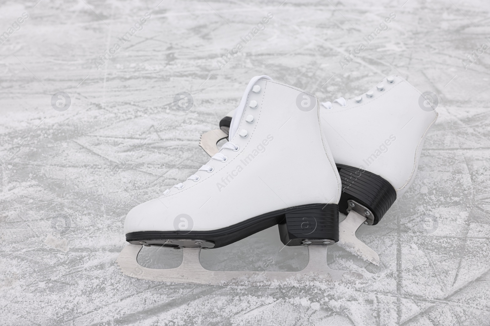 Photo of Pair of white figure skates on ice