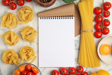 Recipe book surrounded by different ingredients on white marble table, flat lay with space for text. Cooking classes