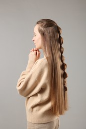 Woman with braided hair on grey background