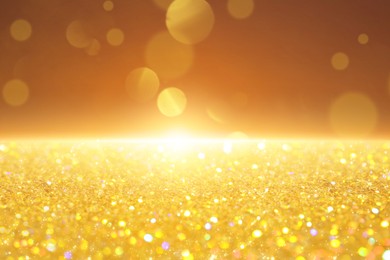 Image of Many golden paillettes against color background. Bokeh effect