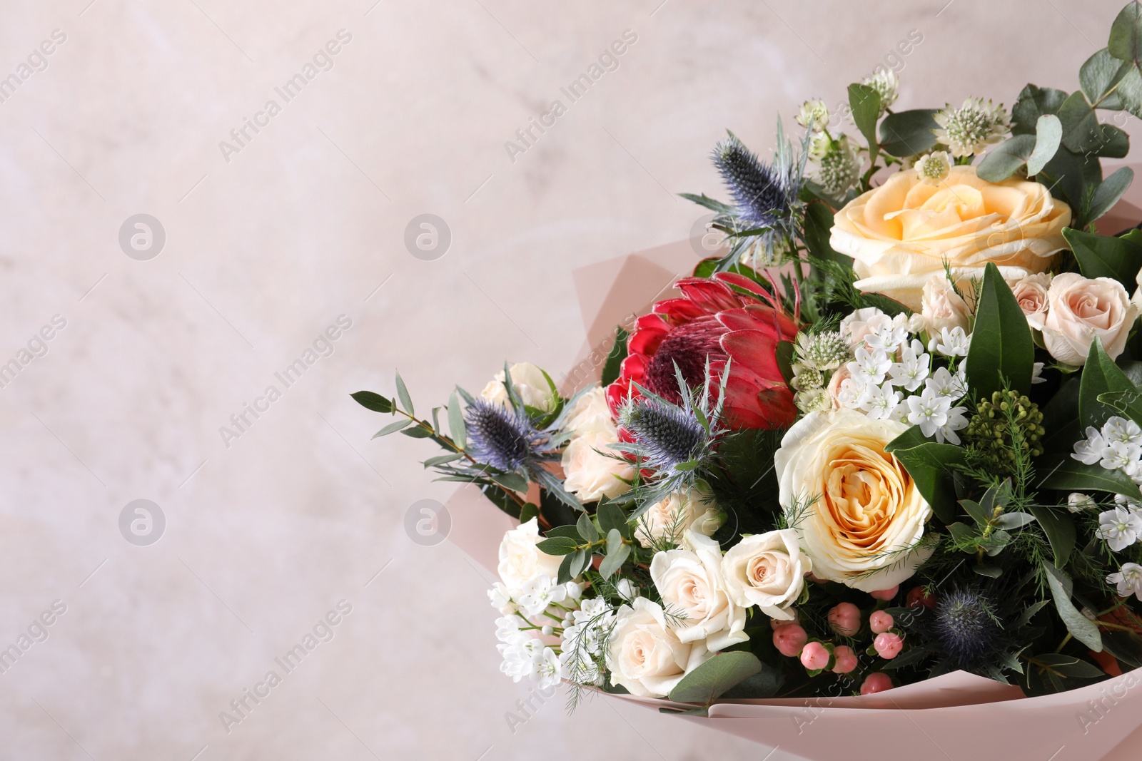 Photo of Beautiful bouquet with roses on beige background, closeup. Space for text