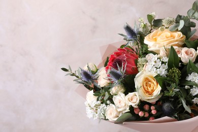 Photo of Beautiful bouquet with roses on beige background, closeup. Space for text