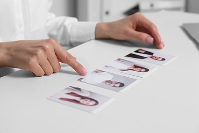 Photo of Human resources manager choosing employee among different applicants at table in office, closeup