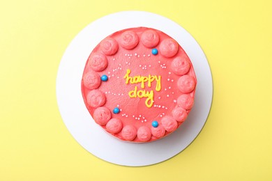 Cute bento cake with tasty cream on yellow background, top view