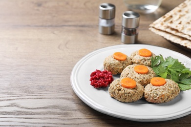 Photo of Plate of traditional Passover (Pesach) gefilte fish on wooden table. Space for text