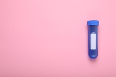 Photo of Test tube with liquid on pink background, top view and space for text. Kids chemical experiment toy