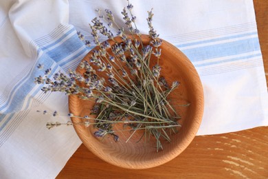 Photo of Bowl with beautiful lavender flowers on wooden table, top view