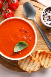 Photo of Delicious tomato soup served on white table, top view