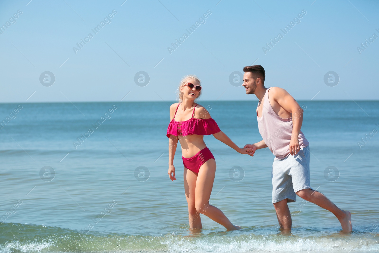 Photo of Happy young couple having fun at beach on sunny day