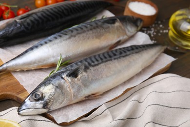 Photo of Raw organic mackerel fish on wooden board, closeup