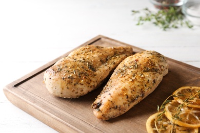 Photo of Baked lemon chicken served on white wooden table