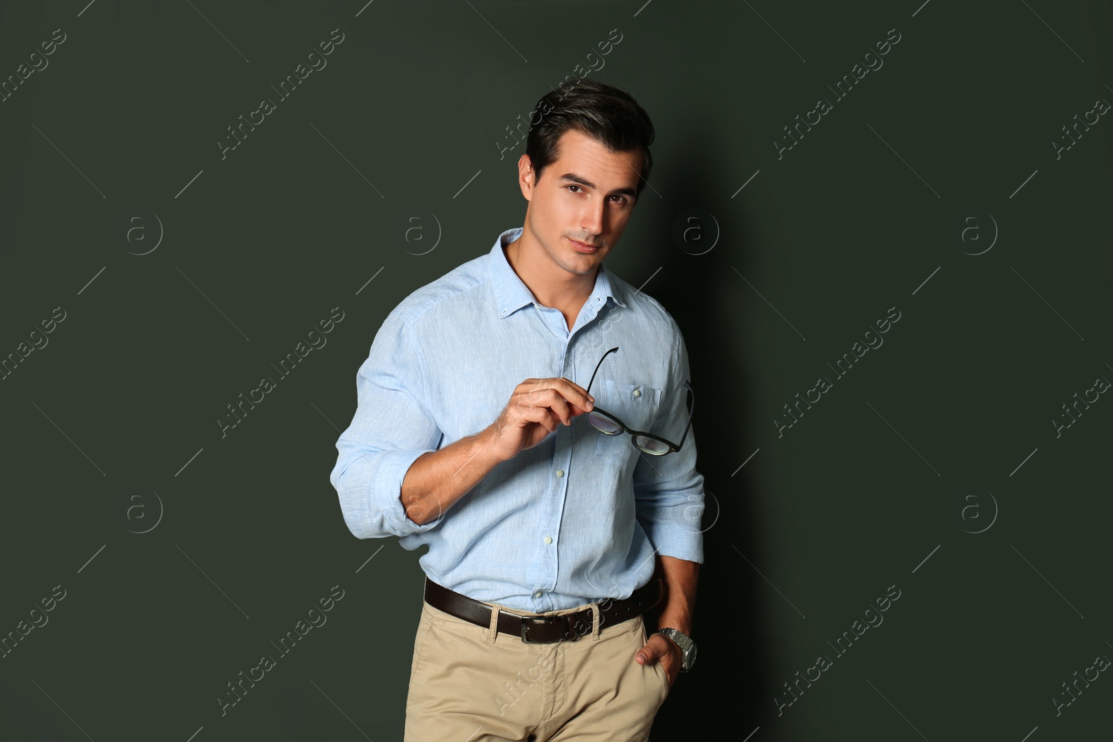 Photo of Handsome young man in stylish clothes with glasses on dark background