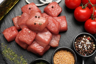 Photo of Raw beef meat and different ingredients for cooking delicious goulash on slate board, flat lay