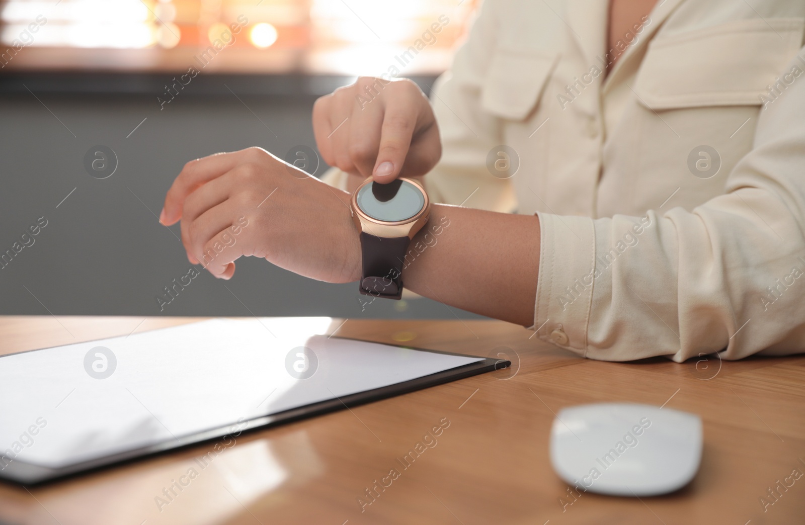 Photo of Woman using modern smart watch in office, closeup