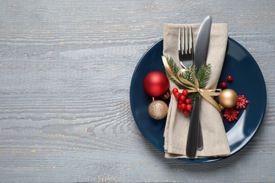 Photo of Festive table setting with beautiful dishware and Christmas decor on grey wooden background, top view. Space for text