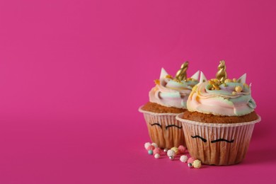 Cute sweet unicorn cupcakes on pink background, space for text