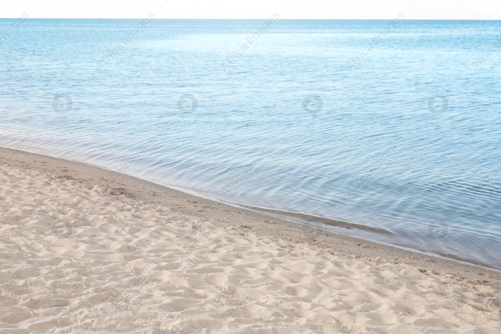 Photo of View of sea water and beach sand on sunny summer day
