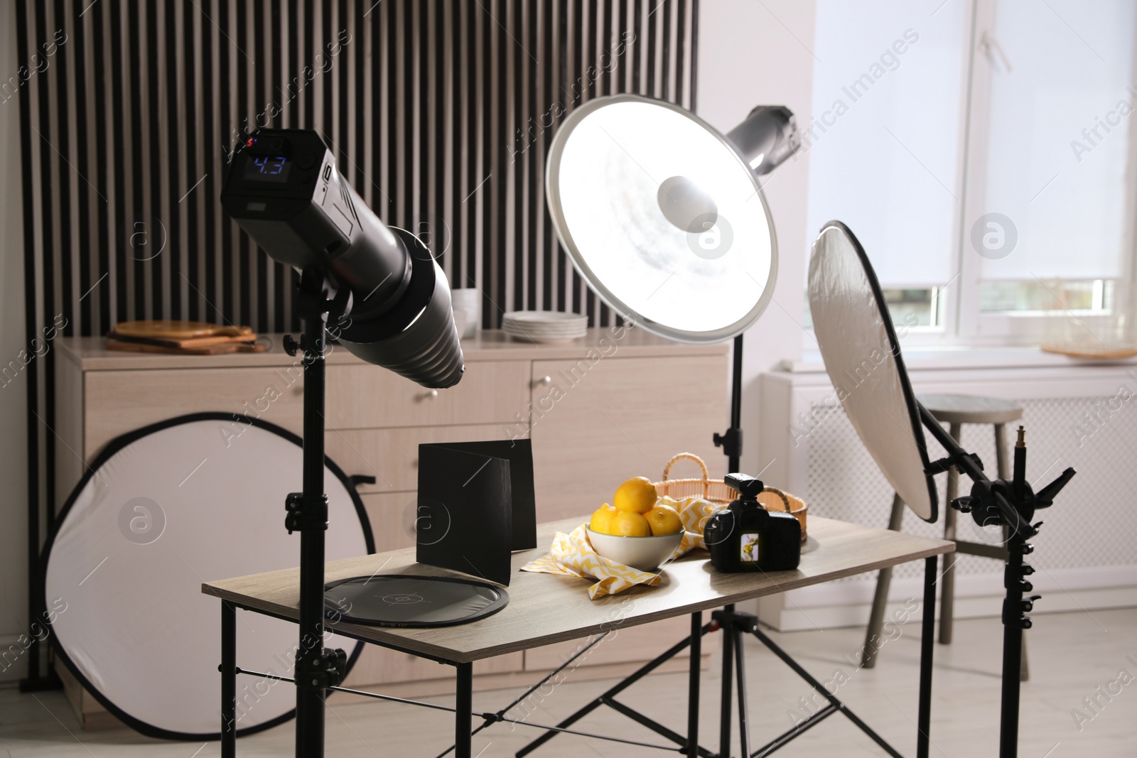 Photo of Professional camera and composition with ripe lemons on table in photo studio. Food photography
