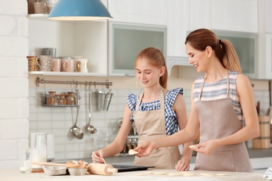 Mother and her daughter with cookie dough in kitchen