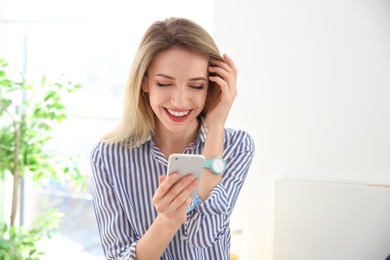 Photo of Young woman using phone indoors